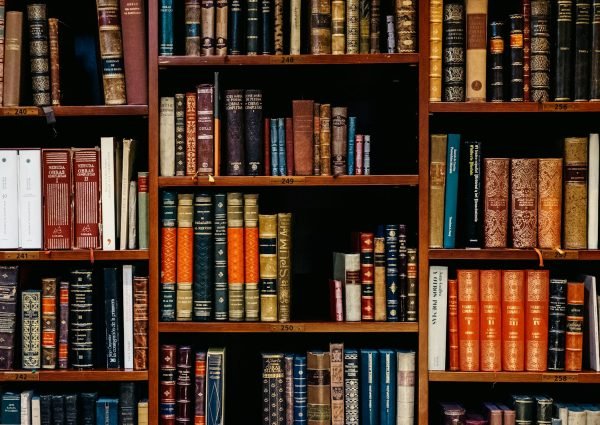 photo by iñaki del olmo assorted-title of books piled in the shelves